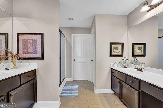 bathroom with tile patterned flooring, an enclosed shower, and vanity