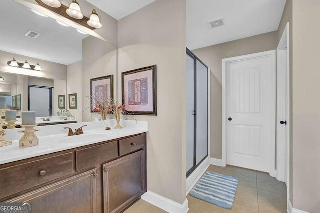 bathroom with tile patterned flooring, a shower with door, and vanity