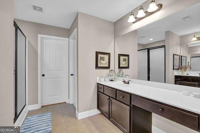 bathroom with an enclosed shower, tile patterned floors, and vanity