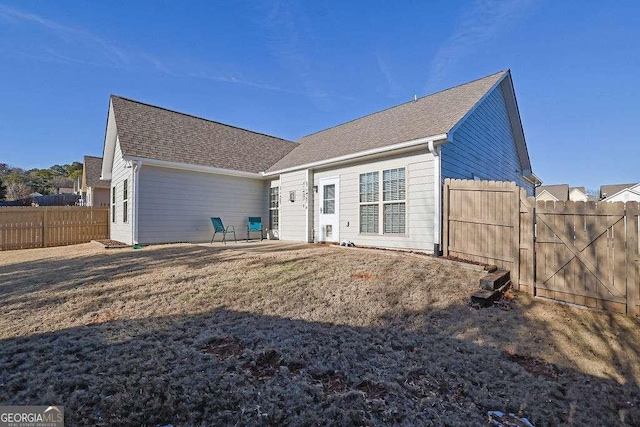 rear view of house with a patio and a yard