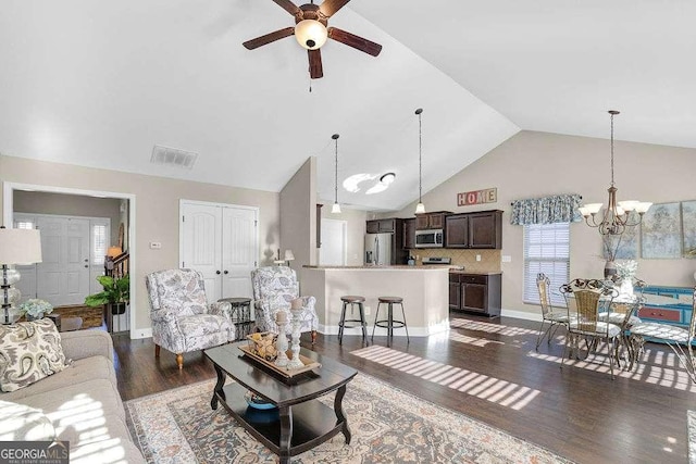 living room with dark hardwood / wood-style flooring, high vaulted ceiling, and ceiling fan with notable chandelier