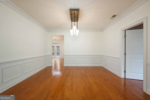 spare room with ornamental molding and hardwood / wood-style flooring