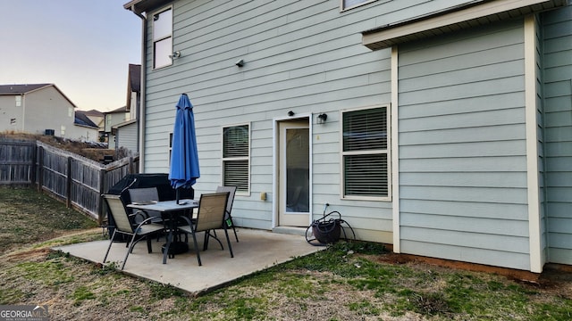 back house at dusk with a patio area