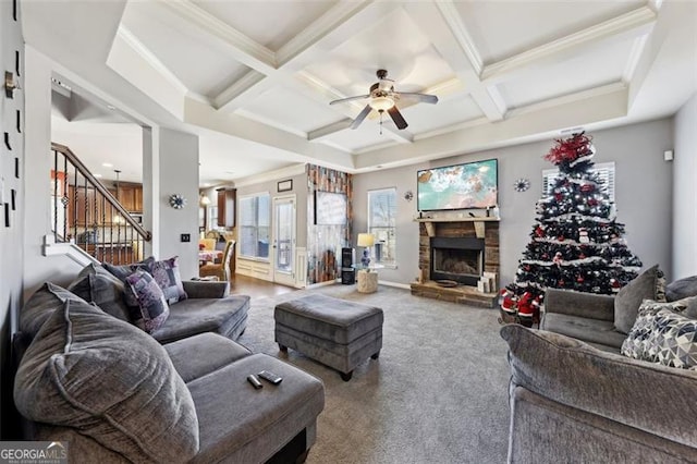 living room featuring coffered ceiling, ceiling fan, carpet flooring, a fireplace, and beam ceiling