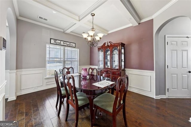 dining area featuring coffered ceiling, crown molding, beamed ceiling, dark wood-type flooring, and an inviting chandelier