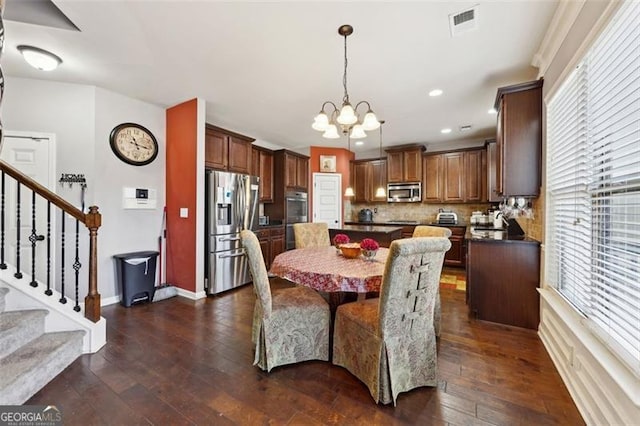 dining area with sink, an inviting chandelier, and dark wood-type flooring