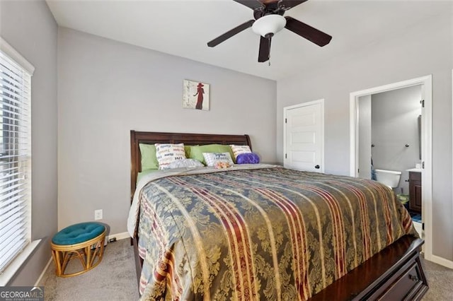 carpeted bedroom with ensuite bath and ceiling fan