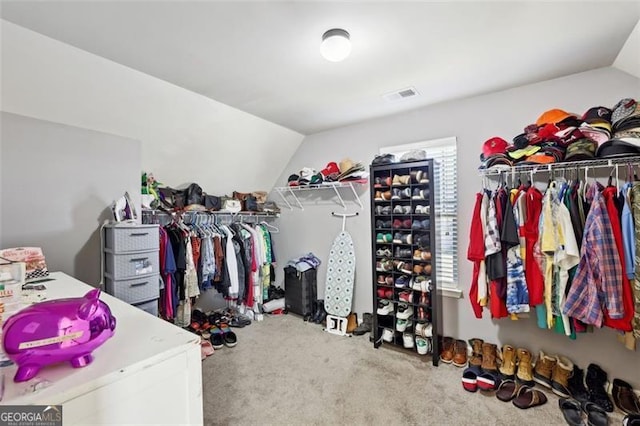 walk in closet with lofted ceiling and carpet floors