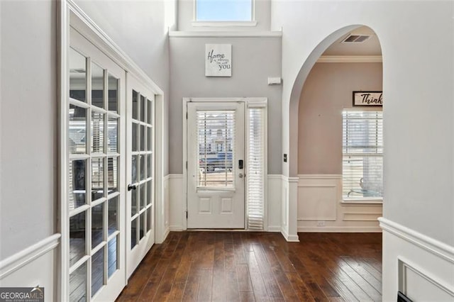 foyer with french doors, crown molding, and dark hardwood / wood-style floors