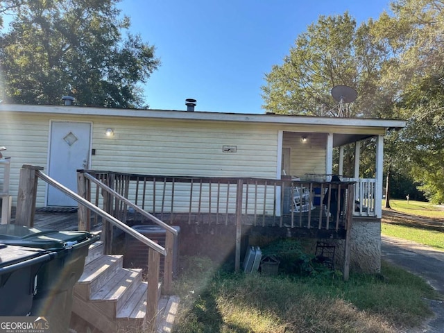 rear view of house with a deck and cooling unit