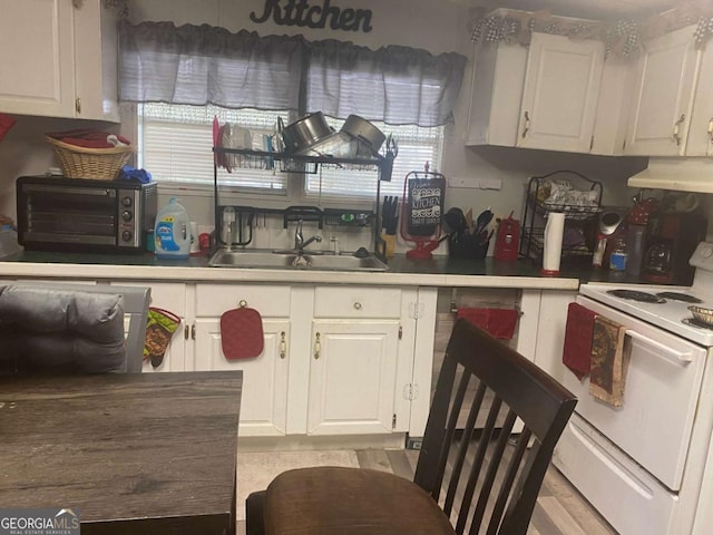 kitchen featuring white cabinets, white range with electric cooktop, and sink