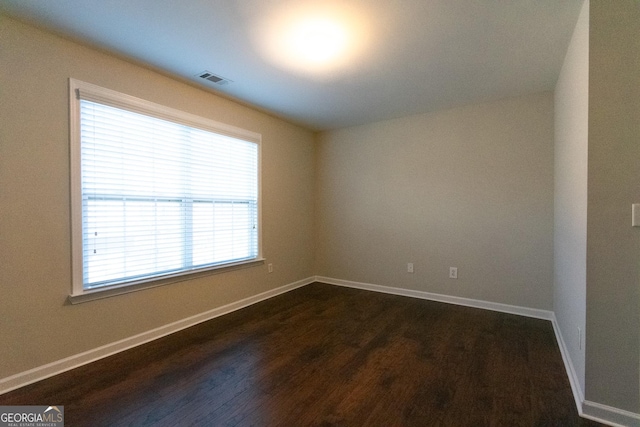 spare room featuring dark wood-type flooring