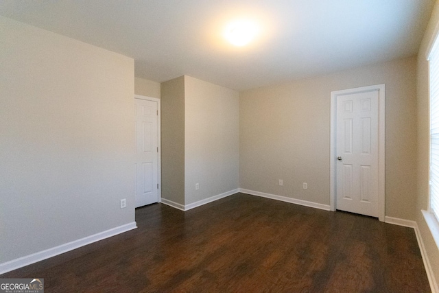 spare room featuring dark wood-type flooring