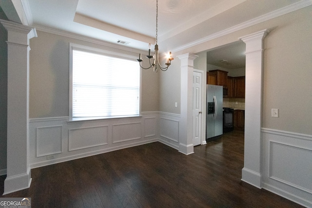 unfurnished dining area featuring an inviting chandelier, dark hardwood / wood-style floors, and a tray ceiling