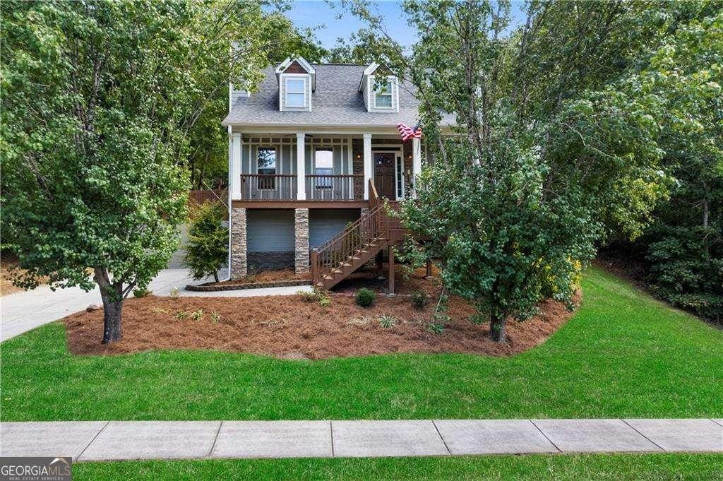 cape cod-style house featuring a front yard and covered porch