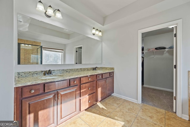 bathroom with tile patterned floors, a raised ceiling, vanity, and a shower with shower door