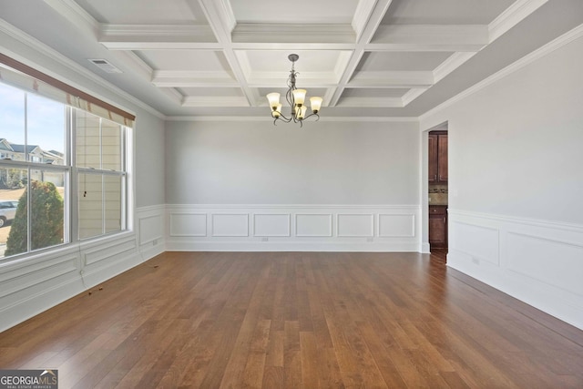 unfurnished room with dark wood-type flooring, beamed ceiling, ornamental molding, a notable chandelier, and coffered ceiling