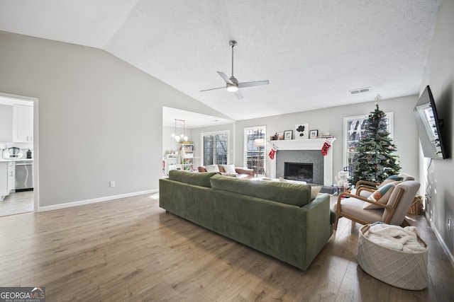 living room featuring a textured ceiling, vaulted ceiling, and hardwood / wood-style floors