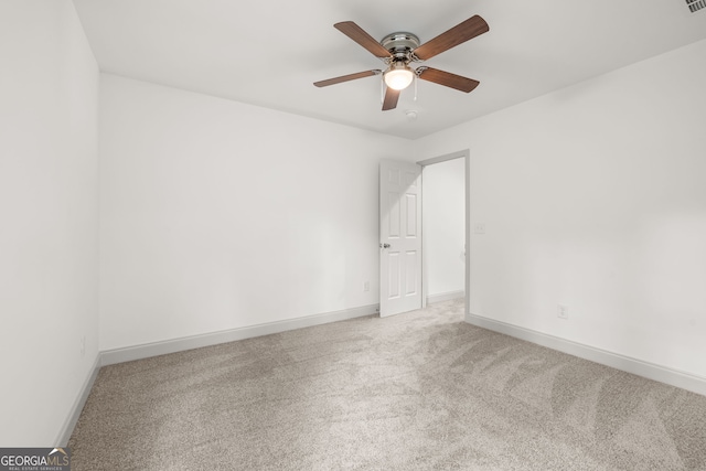 empty room with ceiling fan and light carpet