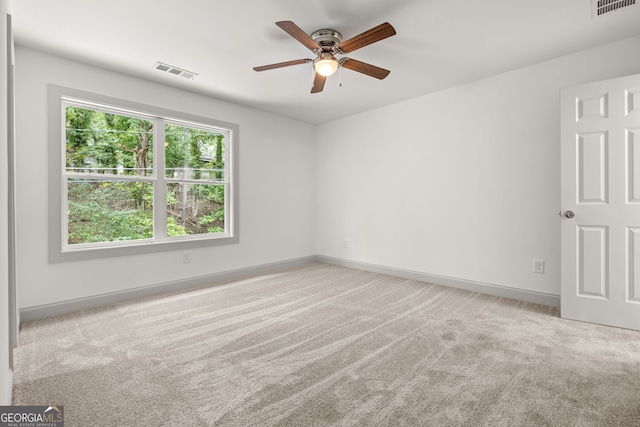 carpeted spare room featuring ceiling fan