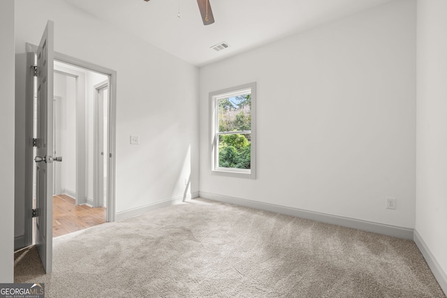 unfurnished room with ceiling fan and light carpet