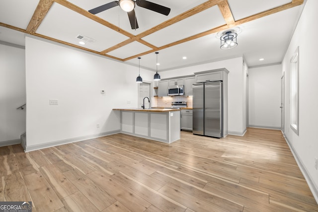 kitchen featuring stainless steel appliances, sink, kitchen peninsula, coffered ceiling, and gray cabinetry