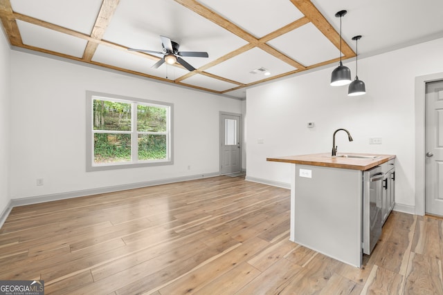 kitchen with wooden counters, decorative light fixtures, coffered ceiling, and sink