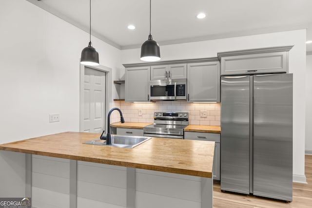 kitchen with sink, hanging light fixtures, gray cabinetry, and appliances with stainless steel finishes