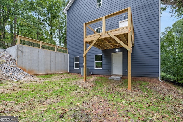 rear view of property featuring a balcony and central AC