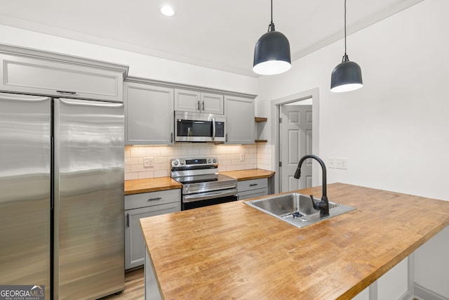 kitchen featuring sink, stainless steel appliances, gray cabinets, and hanging light fixtures