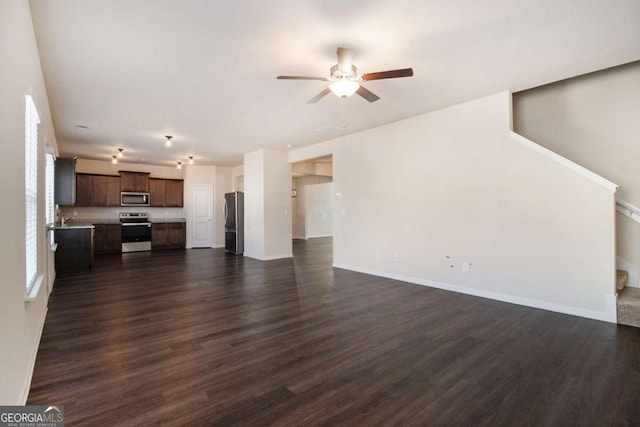 unfurnished living room featuring ceiling fan and dark hardwood / wood-style flooring