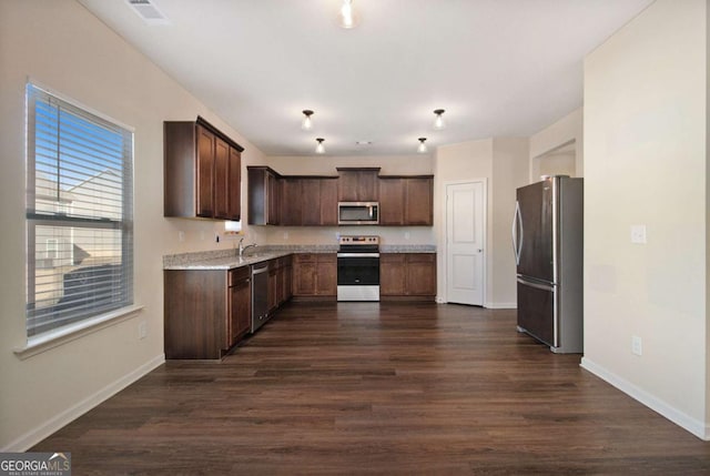 kitchen featuring dark brown cabinetry, sink, dark hardwood / wood-style flooring, and stainless steel appliances