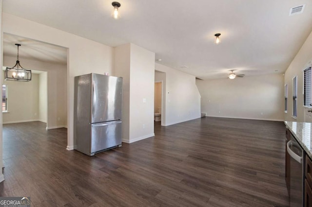 kitchen with hanging light fixtures, ceiling fan with notable chandelier, dark wood-type flooring, and stainless steel appliances