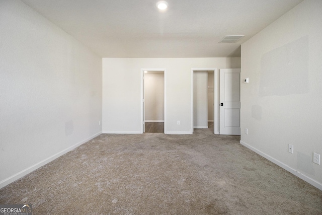 unfurnished bedroom with a spacious closet and carpet flooring