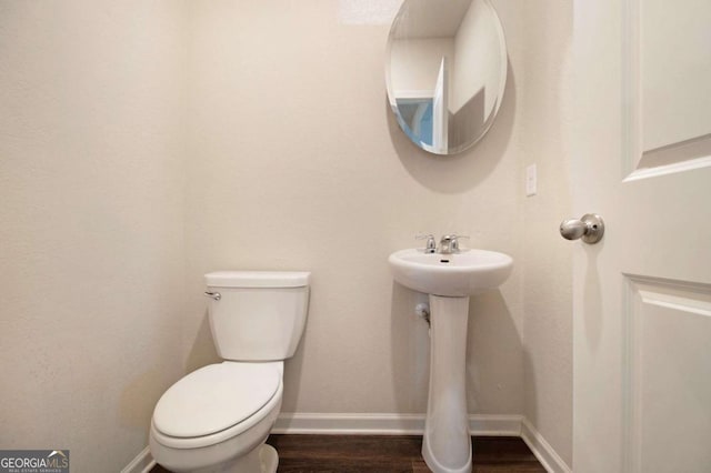 bathroom featuring wood-type flooring and toilet