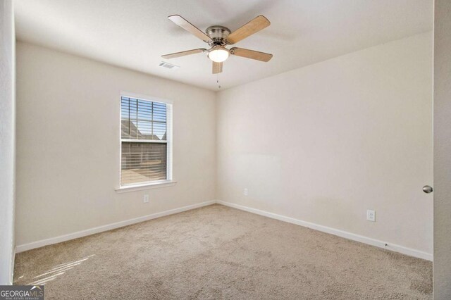 carpeted spare room with ceiling fan