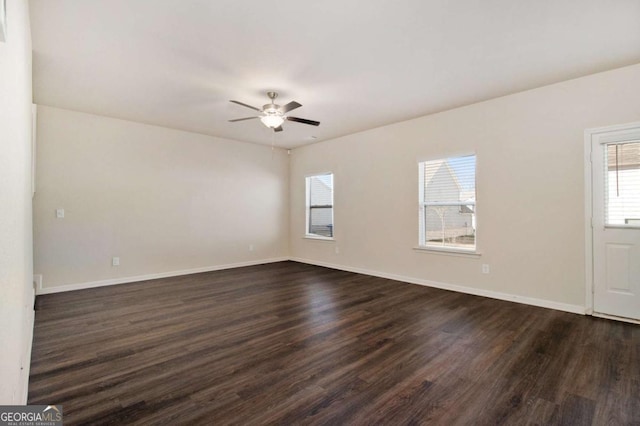 spare room featuring dark wood-type flooring and ceiling fan