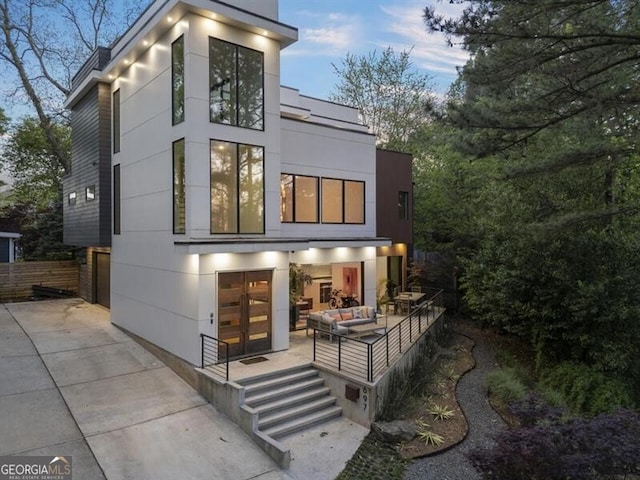 back house at dusk with an outdoor living space