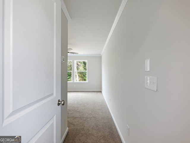 corridor featuring baseboards, carpet floors, and crown molding