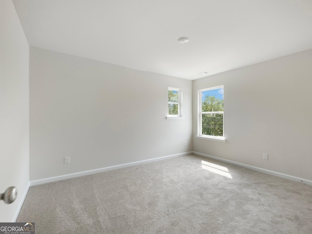 carpeted empty room featuring baseboards