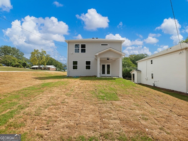 back of property with french doors, a lawn, and ceiling fan