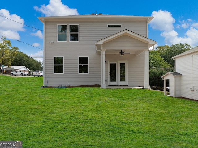 back of property featuring ceiling fan and a yard