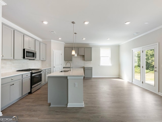 kitchen with tasteful backsplash, appliances with stainless steel finishes, gray cabinets, and a sink