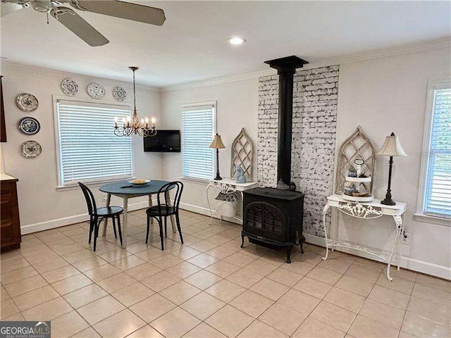 dining area with a healthy amount of sunlight, a wood stove, and crown molding