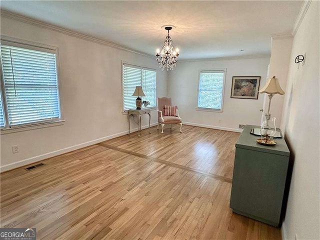 sitting room featuring hardwood / wood-style floors, an inviting chandelier, and crown molding