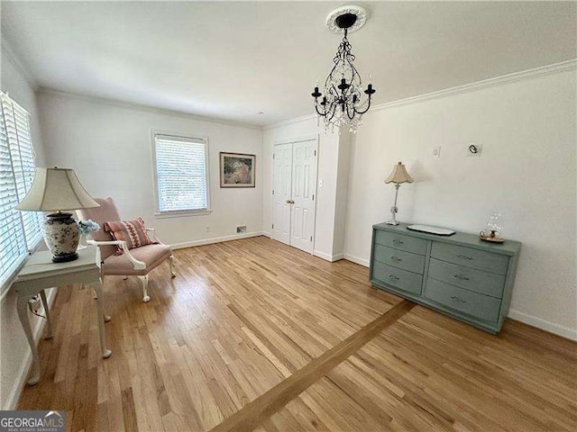 unfurnished room with light hardwood / wood-style floors, an inviting chandelier, and ornamental molding