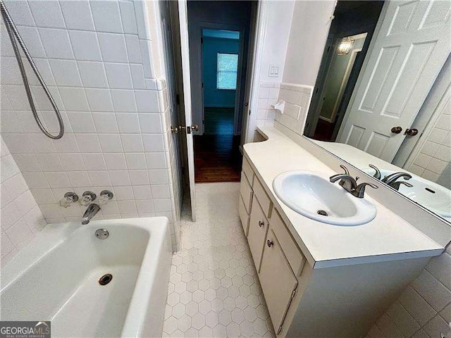 bathroom with tile patterned floors, vanity, tile walls, and a bath