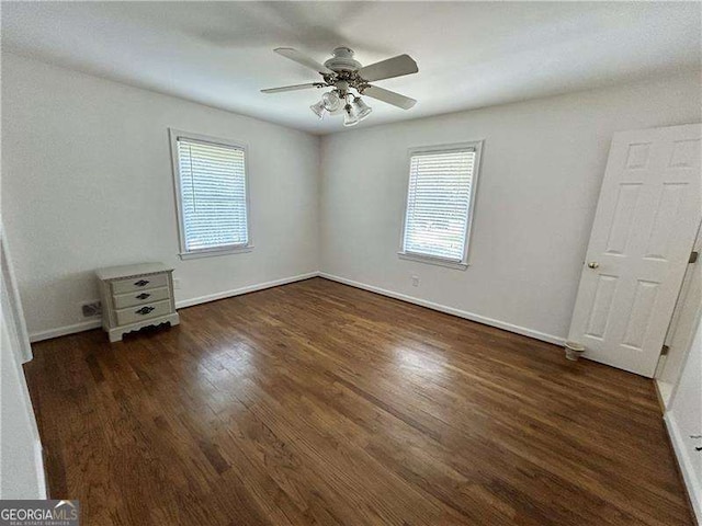 unfurnished bedroom with ceiling fan and dark hardwood / wood-style flooring