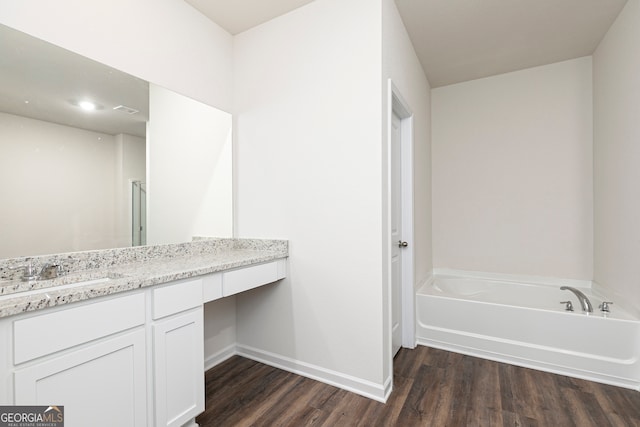 bathroom with a bathing tub, hardwood / wood-style flooring, and vanity