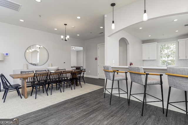 dining area with dark wood-type flooring and a chandelier